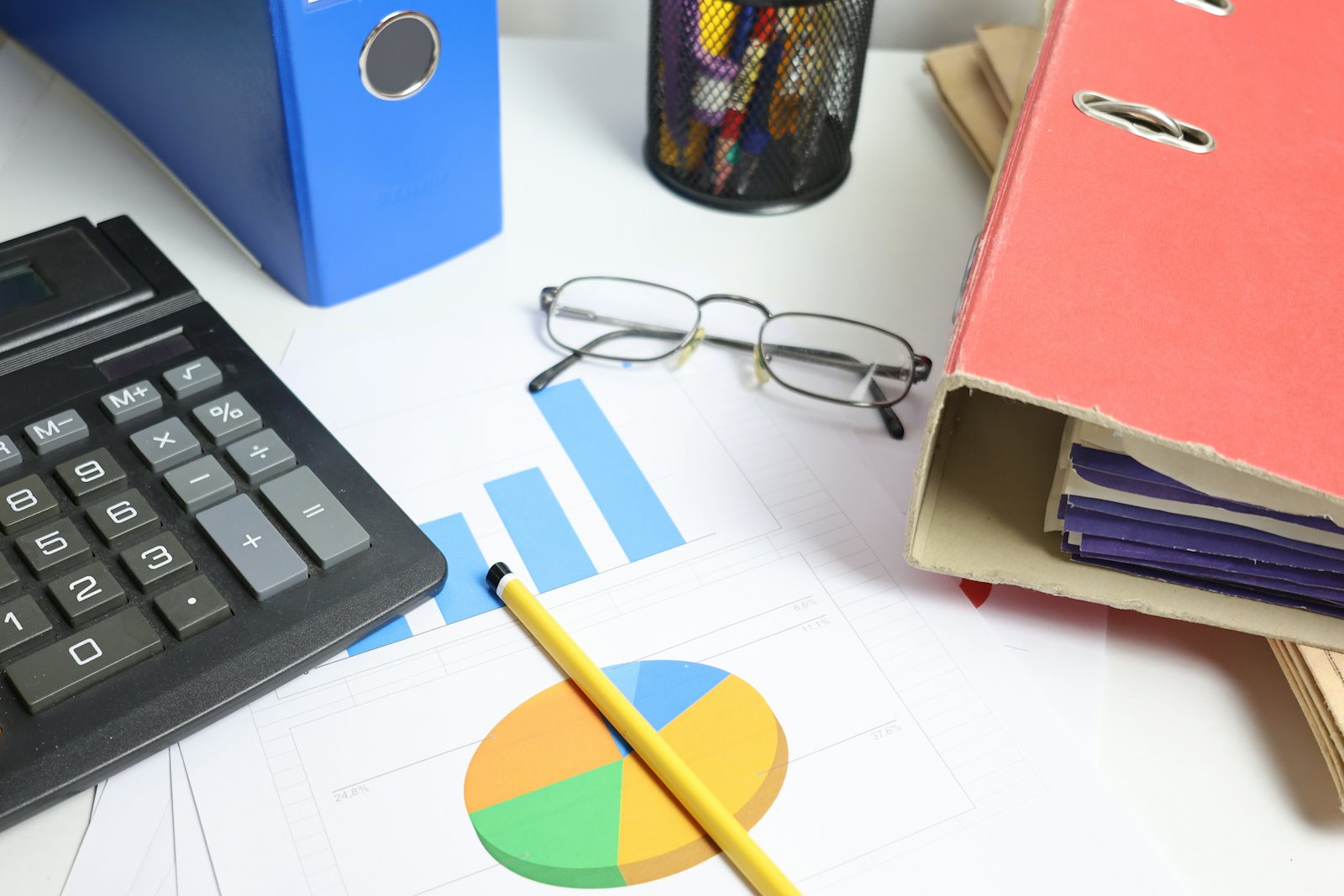 Desk with calculator, charts and binders