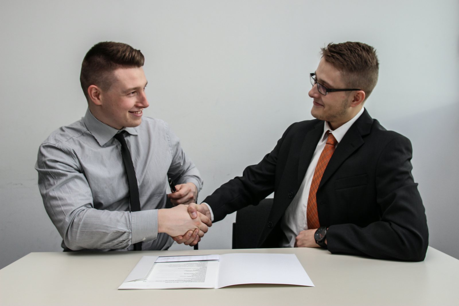Two people shaking hands in a meeting