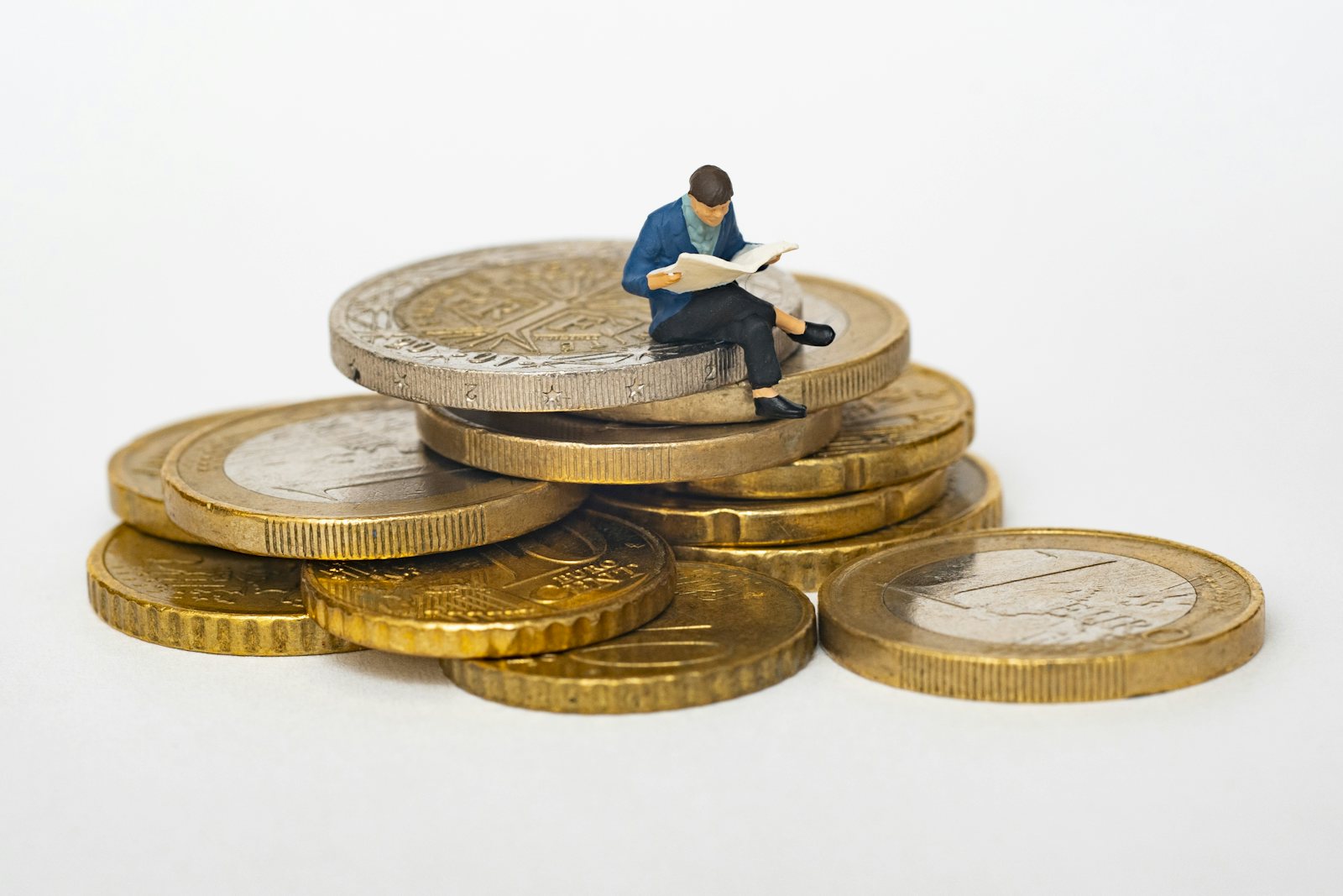 Miniature figure sitting on a stack of coins