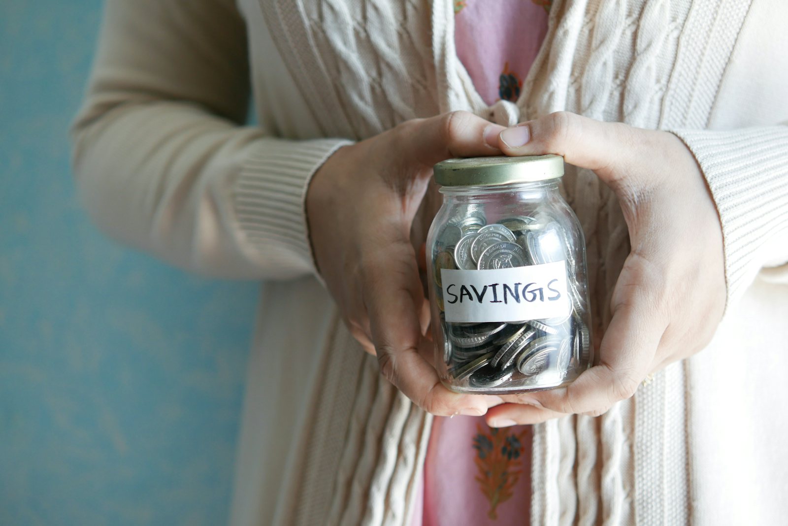 Person holding a jar labelled savings